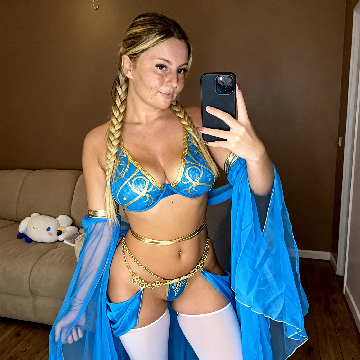 Une femme en costume bleu prend un selfie, souriante et posant devant un miroir.
